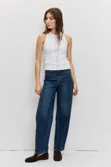 Musculosa blanca de ajuste ceñido con cuello redondo y detalle de apliques metálicos a lo largo de la parte frontal.