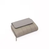 Billetera gris con cierre de cremallera y solapa con broche a presión.