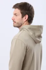 Canguro con capucha de color gris oscuro, confeccionado en tejido de felpa con interior de micropolar. Presenta cordones ajustables en la capucha y un pequeño logo bordado en el pecho.