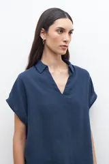 Túnica azul marino con cuello polo y mangas cortas.