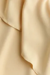 Vestido midi de punto interlock color amarillo, con escote en V, breteles finos y volados diagonales en el frente.