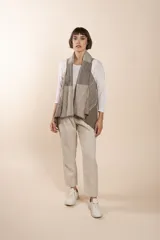 Chaleco de lana fina sin teñir, con diseño patchwork de bloques en tonos grises y marrones. Presenta cuello volcado y terminación a mano en crochet.