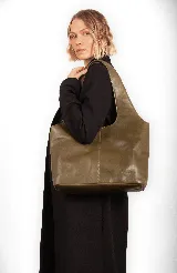 Bolso tipo tote de diseño minimalista, confeccionado en cuero sintético de acabado brillante. Presenta una estructura amplia con costura central vertical y doble asa integrada para llevar al hombro.