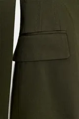 Blazer verde militar entallado con cuello de solapa, manga larga, cierre frontal de un botón y bolsillos con solapa.