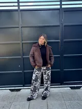 Pantalón largo de tiro bajo con estampado de manchas de vaca en tonos blanco y gris.