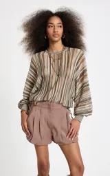 Blusa de punto con rayas verticales en tonos marrón, beige, verde y blanco, corte amplio, escote redondo y mangas largas anchas con puños ajustados.