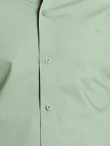 Camisa de manga larga color azul marino, confeccionada en algodón, con cuello abotonado (button-down) y un pequeño logo bordado en el pecho.