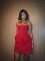 Vestido corto rojo con escote strapless y falda con volados de organza transparente.