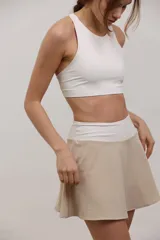 Top deportivo corto de sujeción media, con escote redondo y espalda abierta. Confeccionado en tejido elastizado de poliamida y spandex, con elástico interno en la cintura para mayor ajuste.