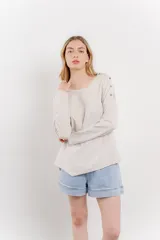 Remera manga larga color rosa con bolsillo en el pecho y corte irregular en el ruedo.