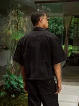 Camisa de gabardina lavada color negro, con rotura en el cuello y parche en la espalda.