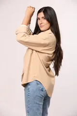 Camisa de pana fina color beige, con cuello clásico, cierre frontal de botones y dos bolsillos con solapa en el pecho.