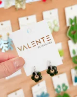 Par de aros colgantes con aro de acero plateado y dije de acrílico verde oscuro con forma de flor.