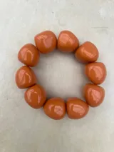 Pulsera elástica compuesta por cuentas de resina de gran tamaño con acabado brillante, disponible en combinaciones de colores gris, naranja y verde.
