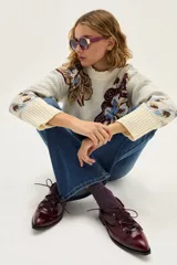 Zapato acordonado de cuero color bordó, con punta fina y diseño estilo oxford. Presenta cordones al tono y detalles de ojales metálicos dorados.