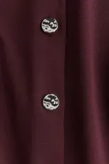 Chaleco bordó de punto interlock pesado, con cuello redondo y cierre frontal con botones de metal con acabado martillado.