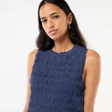 Top azul sin mangas de corte recto, con textura fruncida en todo su diseño, cuello redondo con sutil volado y terminación ondulada en el ruedo.