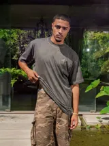 Remera de jersey color gris oscuro con efecto lavado, corte holgado y cuello redondo. Presenta un pequeño logo estampado en el pecho y un estampado grande en la espalda.