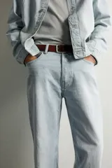 Jeans de corte recto color celeste claro, con tiro medio, diseño de cinco bolsillos, efecto lavado y bajo con acabado irregular deshilachado.