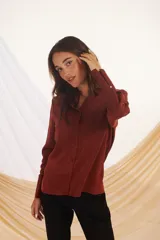 Camisa marrón de manga larga con puños abotonados y cuello clásico.