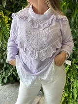 Sweater lila de punto calado con volados en el cuello, el pecho y los puños.