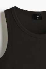 Musculosa H&M de corte ajustado, confeccionada en tejido de punto acanalado de mezcla de algodón. Presenta cuello redondo y bajo recto.