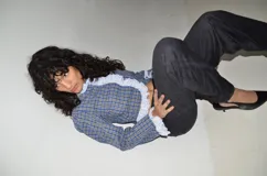 Camisa crop de manga larga con estampado de cuadros en tonos azules y amarillos. Presenta un diseño con volados de encaje blanco tipo festón que recorren el frente y los puños.