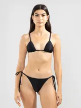 Conjunto de bikini negro con corpiño triangular de breteles finos y bombacha cavada con lazos laterales.