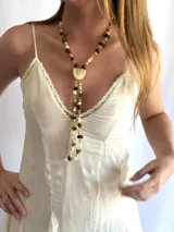 Collar largo estilo gravata con cuentas de piedras naturales en tonos marrones y beige, perlas, cuentas de cristal y un dije central semilunar de nácar.