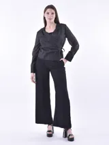 Blusa negra cruzada con lazo lateral, escote en V y mangas largas.