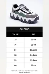 Bota alta marrón de diseño slouchy con plataforma track y múltiples hebillas metálicas decorativas en la parte lateral exterior de la caña.