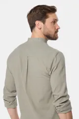 Camisa de lino color verde claro, con cuello mao, manga larga y botones personalizados.