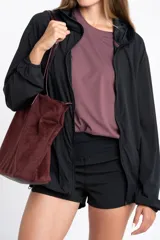 Campera deportiva negra de corte ajustado, con cierre frontal, cuello alto y mangas largas con puños elásticos.