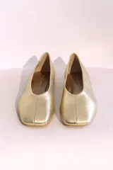 Ballerinas doradas con punta redondeada y suela plana color madera.