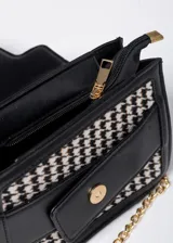 Cartera de mano con estampado pata de gallo en blanco y negro, detalles en cuero sintético negro y correa de cadena dorada.