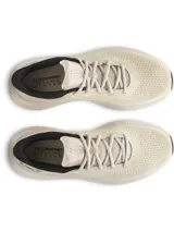 Championes de running Under Armour modelo Charged Rogue 5, color beige con detalles en negro. Presentan una parte superior de malla técnica transpirable, entresuela Charged Cushioning para mayor amortiguación y suela de goma resistente.