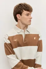 Chomba de friza de manga larga con diseño de rayas horizontales anchas en color beige y azul, cuello polo y pequeño bordado en el pecho.