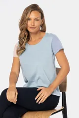 Remera de manga corta con cuello redondo y diseño de bloques de color. El cuerpo es beige, la manga izquierda es azul claro y la manga derecha es rosada.