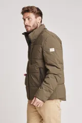 Cazadora acolchada tipo puffer color verde militar, con capucha desmontable, cierre frontal y bolsillos laterales con cierre.