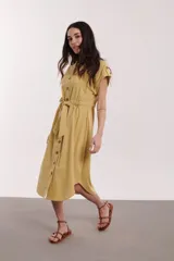 Vestido midi color crudo, con cuello camisero, mangas cortas con botón y lazo en la cintura.