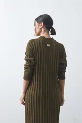Vestido midi de punto en color gris, con diseño de tejido acanalado vertical, cuello redondo y mangas largas. Presenta una silueta recta y fluida.