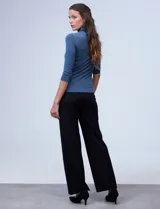 Polera negra de cuello alto y mangas 3/4, confeccionada en tejido elastizado.