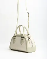 Cartera estilo baúl de color verde claro, combinada con tejido texturizado en el cuerpo principal y detalles en símil cuero. Cuenta con asas de mano rígidas, correa larga ajustable y extraíble, y herrajes metálicos plateados con el logo de la marca en la parte frontal.