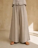Pantalón ancho color beige de lino, con diseño de perneras holgadas y detalle de doble ruedo.