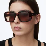 Lentes de sol con montura oversized cuadrada de diseño bold y cantos suavizados. Presentan un estampado carey en la montura y lentes polarizadas color marrón con protección UV400.