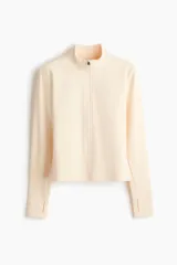 Campera deportiva SoftMove color salmón, de corte ajustado, cuello elevado, cierre frontal completo y mangas largas con abertura para el pulgar.
