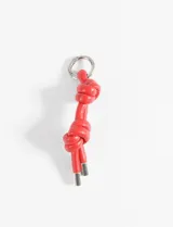 Llavero rojo con cordón de cuero sintético trenzado con nudos y terminales metálicas plateadas.