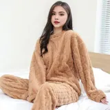 Conjunto de pijama de dos piezas confeccionado en plush suave con textura de ochos. Incluye una remera de manga larga con cuello redondo y un pantalón de corte recto con cintura elástica.