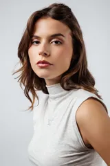 Musculosa color beige con cuello alto y bordado del isotipo de la marca en el frente.