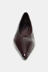 Zapato de piel color marrón oscuro (casi negro), con punta fina y tacón bajo tipo kitten de 4 cm.